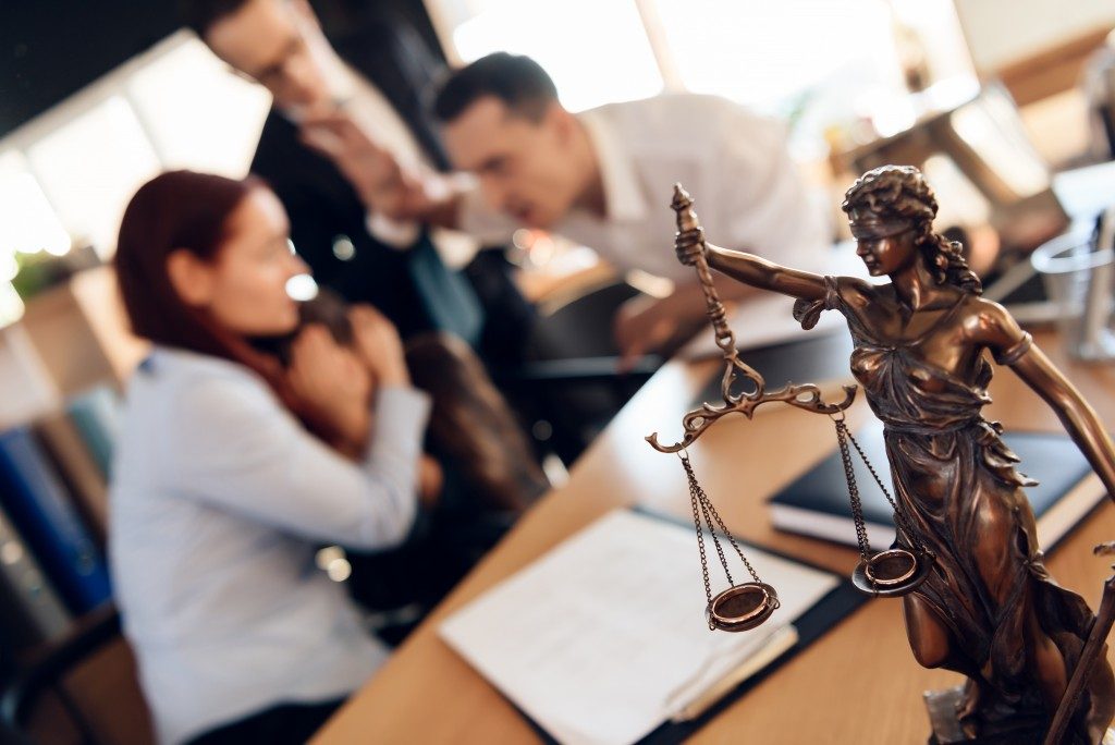 Lady justice figure with couple arguing about divorce with their lawyer and their daughter