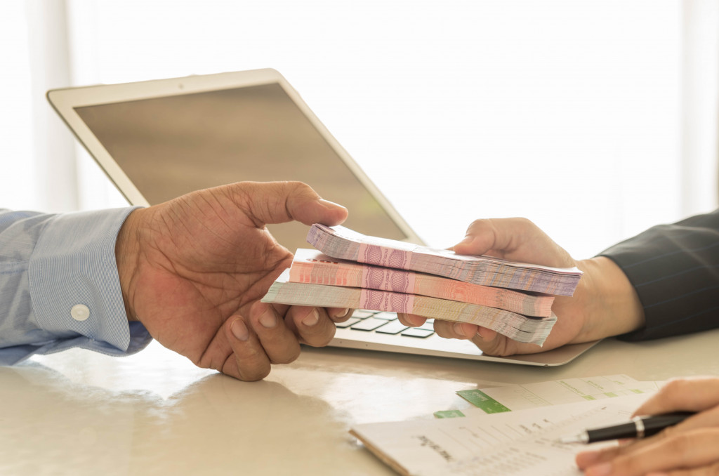 a financial provider handing cash loan to a businessman