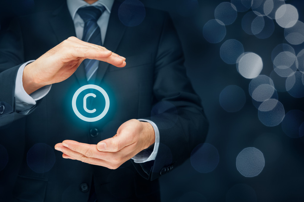 A businessman holding a glowing copyright symbol