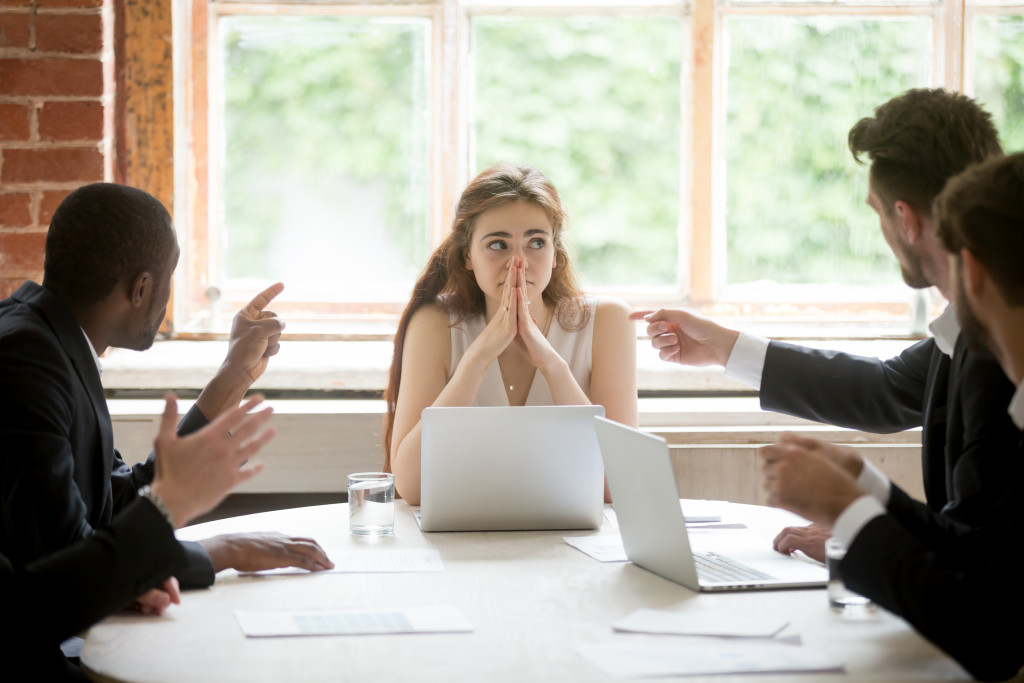 employees pointing at girl businesswoman in meeting room