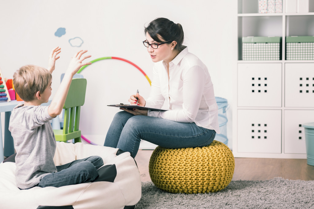 A counselor or expert evaluating, talking to a boy