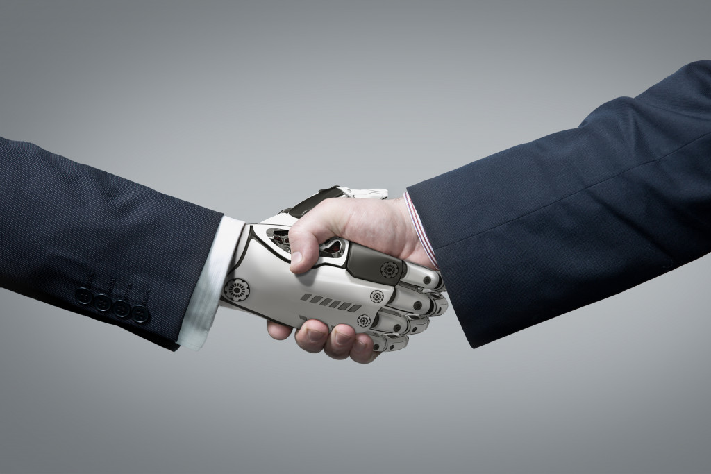 robot hand shaking hands with human hand